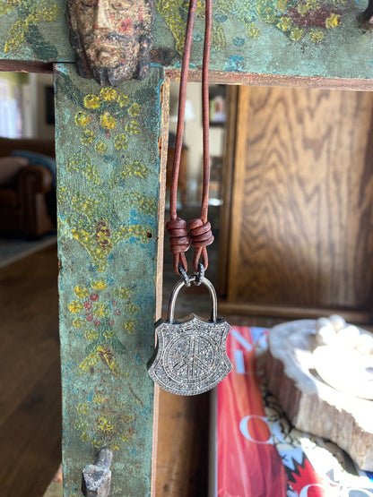 Dark brown leather cord with pave diamond "peace" lock.