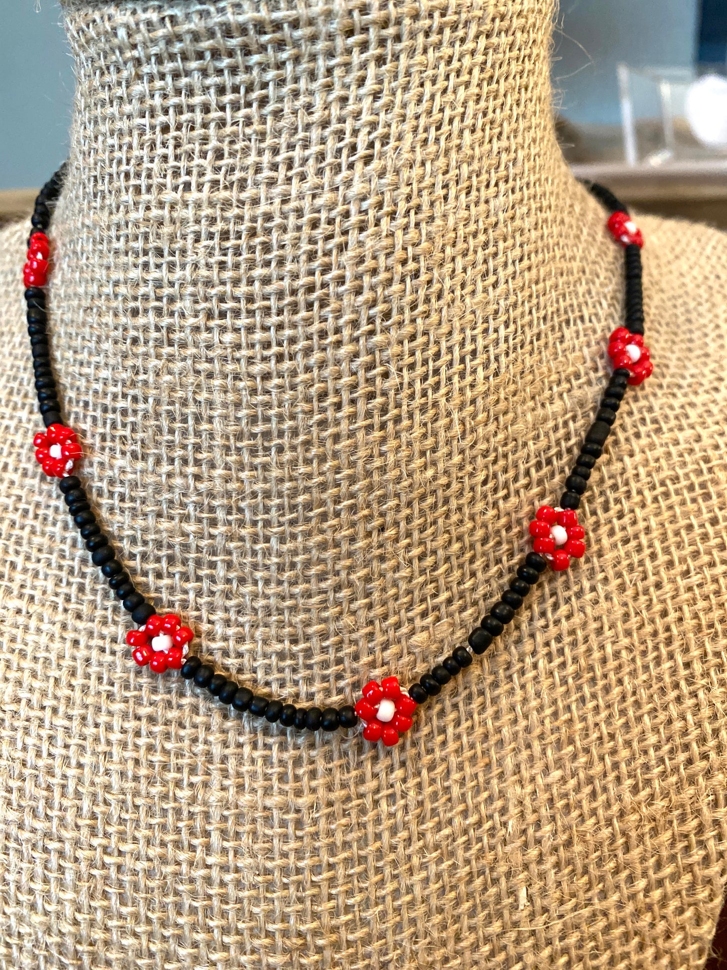Tiny Black Beaded Daisy Chain Necklace With Red and White Flowers.